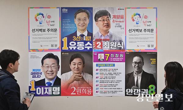 인천 계양구선거관리위원회 관계자들이 제22대 국회의원선거 후보자들의 선거 벽보를 살펴보고 있다. 2024.3.27 /조재현기자 jhc@kyeongin.com