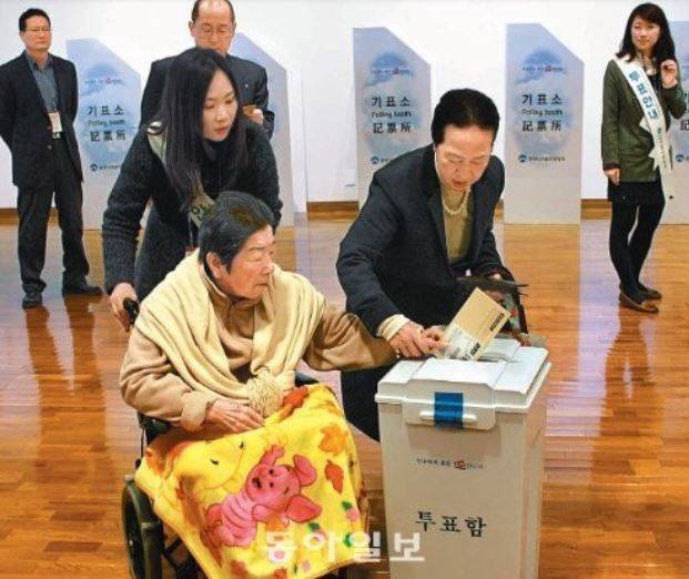 2012년 12월 5일 오전 10시 반 일본 도쿄 신주쿠 한국문화원 1층에 마련된 대통령 선거 재외국민투표 투표소에서 유권자가 휠체어를 타고 딸의 도움을 받아가며 한 표를 행사하고 있다. 동아일보DB