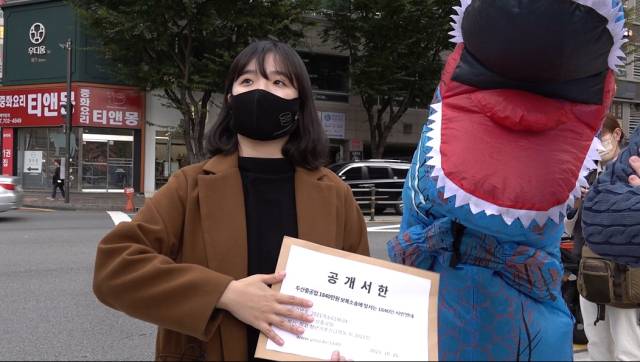 ▲강은빈 청년기후긴급행동 활동가가 두산중공업의 베트남 소재 석탄화력발전소 건립을 항의하는 공개서한을 들고 있다. ⓒ공생공