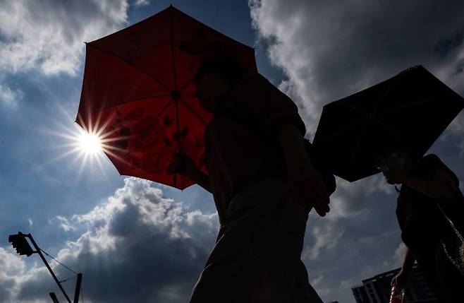 폭염경보가 내린 지난 7월23일 동대구역 광장에서 시민들이 양산을 쓰고 이동하고 있다. 연합뉴스