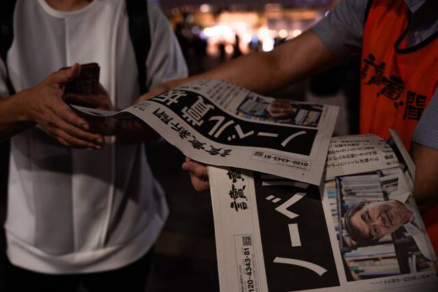 일본 요미우리신문 직원들이 6일 도쿄 거리에서 사카구치 시몬 오사카대 명예교수가 노벨 생리의학상을 수상자로 선정됐다는 기사가 실린 호외를 독자들에게 배포하고 있다. 도쿄/AP 연합뉴스