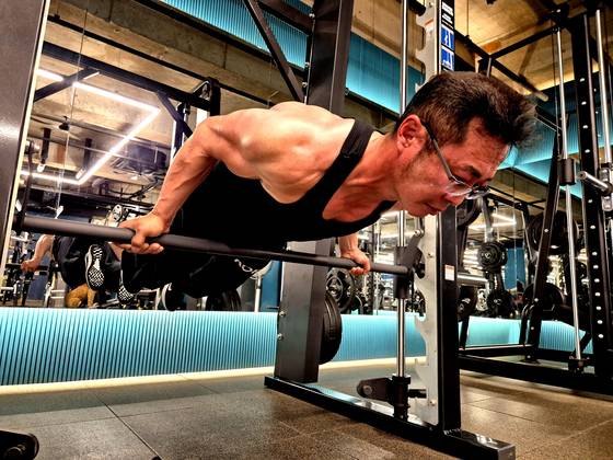 At a gym in Gimhae, South Gyeongsang, 55-year-old Seo Sang-jin warms up for arm-wrestling practice with a planche, a move known as the ultimate test of bodyweight strength. [AN DAE-HUN]