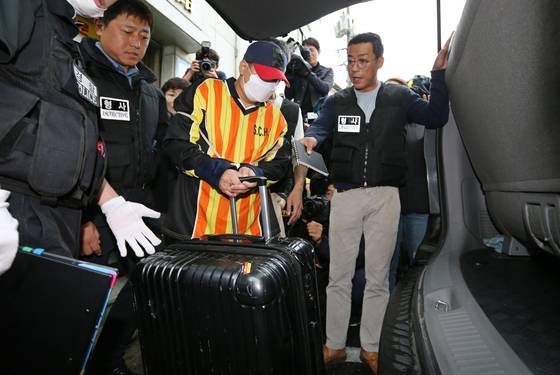 Lee Young-hak, center, reconstructs putting a suitcase with the victim's body into his vehicle in Jungnang District, eastern Seoul, on Oct. 11, 2017. [JOINT PRESS CORPS]