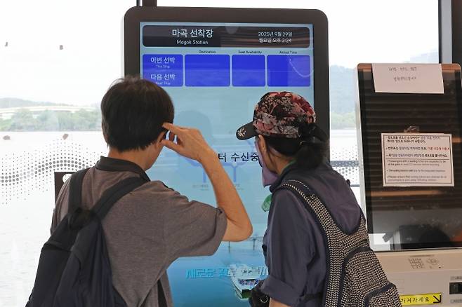 한달 동안 무승객 시범운항 나선 한강버스 - 한강버스가 시민 탑승을 일시 중단한 가운데 29일 서울 강서구 마곡선착장을 찾은 시민이 공란인 시간표 현황판을 바라보고 있다. 지난 18일 정식 운항을 시작한 한강버스는 이날부터 한 달 동안 성능 고도화와 안정화를 위한 ‘무승객 시범운항’에 나선다.  연합뉴스