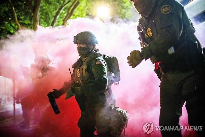 미국 연방요원들과 경찰이 5일(현지시간) 미국 오리건주 포틀랜드의 이민세관단속국(ICE) 시설 인근 시위대를 해산시키려고 최투탄을 투척하고 있다. [AP=연합뉴스]