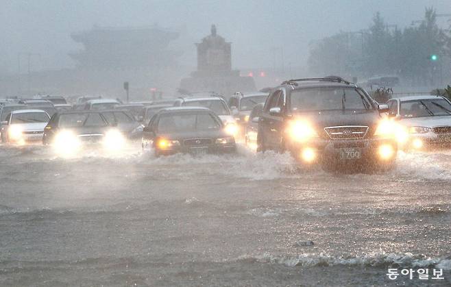 시간당 최고 100㎜에 달하는 기습폭우가 쏟아지면서 광화문 사거리가  물바다가 된 가운데 차량들이 조심스럽게 운행하고 있다. 동아일보 DB