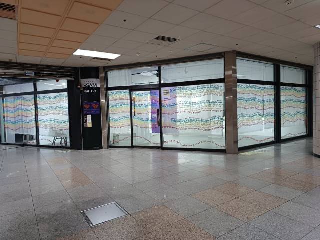 ▲피해자 측 201명이 보낸 <재미진 복수-밑그림>에 대한 응원과 지지의 메시지가 무지개색깔로 전시장 유리벽을 둘러싸고 있다. 화사는 <케이팝 데몬 헌터스>에서 악령을 막아주는 '혼문'을 떠올리며 이 유리벽을 '무지개 혼문'이라 명명한다.