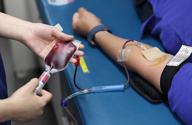 세계 헌혈자의 날을 하루 앞둔 13일 서울 종로구 광화문광장에 마련된 헌혈버스에서 한 시민이 헌혈을 하고 있다. <연합뉴스>