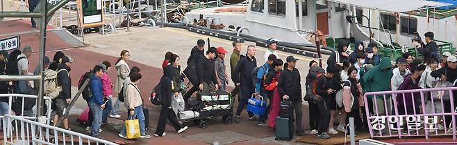 추석연휴 마지막 날인 9일 인천연안여객터미널 잔교에서 섬에 돌아오는 귀경객들이 고향의 선물을 한아름 안고 여객선을 내리고 있다. 2025.10.9 /김용국기자yong@kyeongin.com