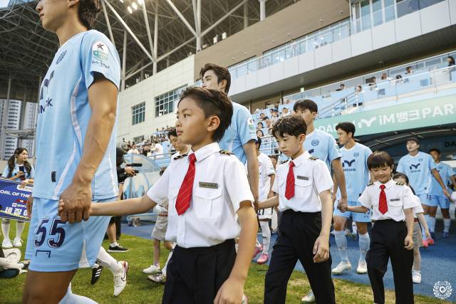 둘째 지후(오른쪽 맨앞)가 지난 8월 대구iM뱅크PARK에서 열린 대구FC 홈경기에서 한 축구선수 손을 잡고 입장하고 있다. 김정훈 씨 제공