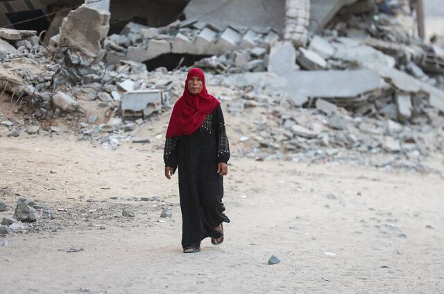 이스라엘과 하마스가 휴전에 합의했다고 도널드 트럼프 미국 대통령이 발표한 8일(현지시각) 팔레스타인 가자지구 칸 유니스에서 한 여성이 이스라엘의 공격으로 폐허가 된 거리를 걷고 있다. 칸 유니스/로이터 연합뉴스