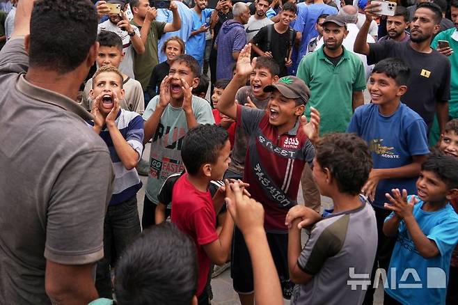 [AP/뉴시스] 미 트럼프 대통령에 의해 이스라엘과 하마스 간 휴전 합의 소식이 전해진 얼마 뒤인 9일 아침 가자 지구 팔레스타인 사람들이 휴전 성사에 기뻐하고 있다. 가자 중부 데이르 알발라의 알아크사 병원 모습이다.