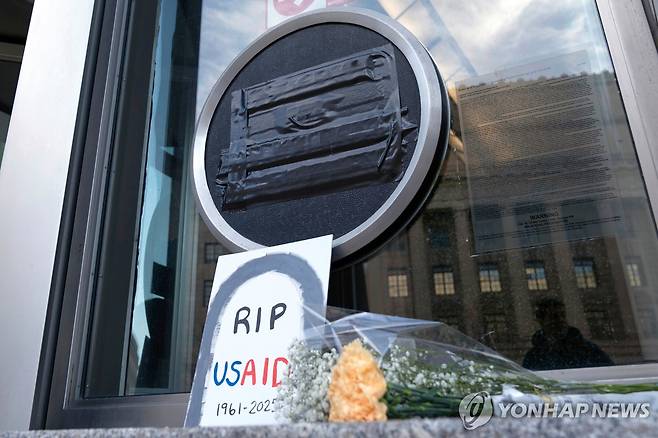 미국국제개발처 본부 앞에 놓인 '근조' 꽃과 팻말 [AP 연합뉴스 자료사진. 재판매 및 DB 금지]