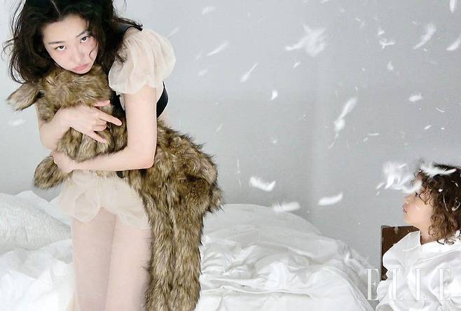 시폰 드레스와 하네스, 손에 든 페이크 퍼 액세서리는 모두 Simone Rocha.