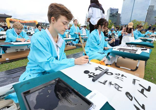 '2025 제16회 광화문광장 휘호대회'에 참가한 외국인들이 한글날인 9일, 서울 종로구 광화문광장에서 붓글씨로 한글을 쓰고 있다. 뉴스1