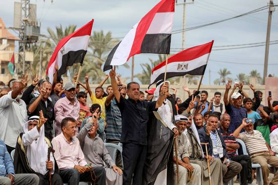 가자지구 중부 데이르 알 발라에 있는 이집트 위원회 본부 앞에서 이스라엘과 하마스가 가자 정전 협상에 합의했다는 발표가 나온 후 팔레스타인 사람들이 기뻐하고 있다. 연합뉴스