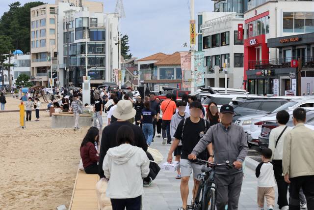 ▲ 추석 황금연휴 첫날인 3일 강릉 안목해변 커피거리에 관광객이 붐비며 연휴를 만끽했다. 관광객들이 백사장에서 즐거운 한때를 보내고 있다.  황선우 기자