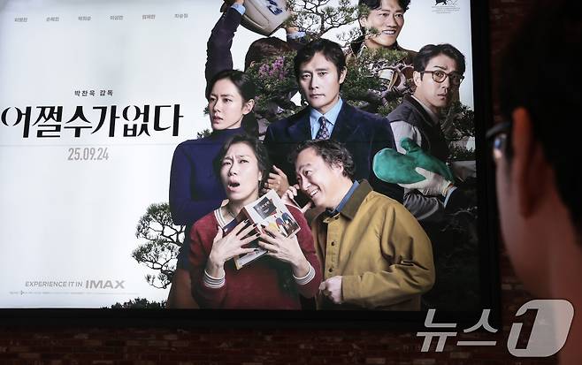 25일 서울도심의 한 영화관에서 관객이 박찬욱 감독의 영화 '어쩔수가없다' 포스터를 바라보고 있다. 2025.9.25/뉴스1 ⓒ News1 권현진 기자