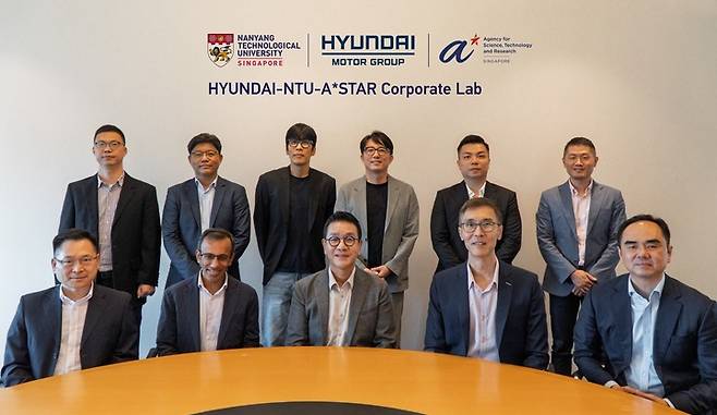 현대차그룹 최초의 스마트팩토리이자 소프트웨어 중심 공장 테스트베드인 HMGICS는 지난 3일 싱가포르 난양공대에서 난양공대, 싱가포르 과학기술청과 HMGICS내에 '현대차그룹-난양공대-싱가포르 과학기술청 기업 연구소'를 개소했다.(앞줄 왼쪽부터) NTU 람쿽얀 부부총장, HMGICS CIO 알페시 파텔 상무, HMGICS 법인장 박현성 상무, 싱가포르 과학기술청 과학 및 공학 연구 위원회 림켕후이 부청장, 싱가포르 과학기술청 데이비드 로우. (뒷줄 왼쪽부터) 난양공대 후궈창 교수, 난양공대 문승기 부교수, 현대차 제조SW개발실 민정국 상무, HMGICS Core R&D lab 한승훈 상무, 싱가포르 경제개발청 이던 림 부본부장, 싱가포르 과학기술청 연구개발부문 왕 웨이 부총괄책임자.