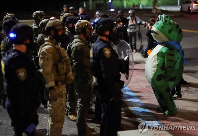 포틀랜드에서 개구리 복장으로 ICE 요원과 대치 중인 한 시위자.연합뉴스