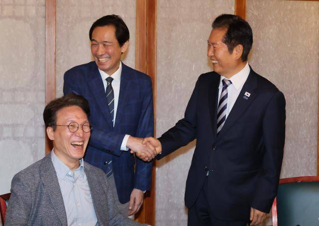 정청래(오른쪽) 더불어민주당 대표와 우상호 정무수석이 12일 서울 종로구 총리공관에서 열린 고위당정협의회에 참석해 악수하고 있다. 연합뉴스