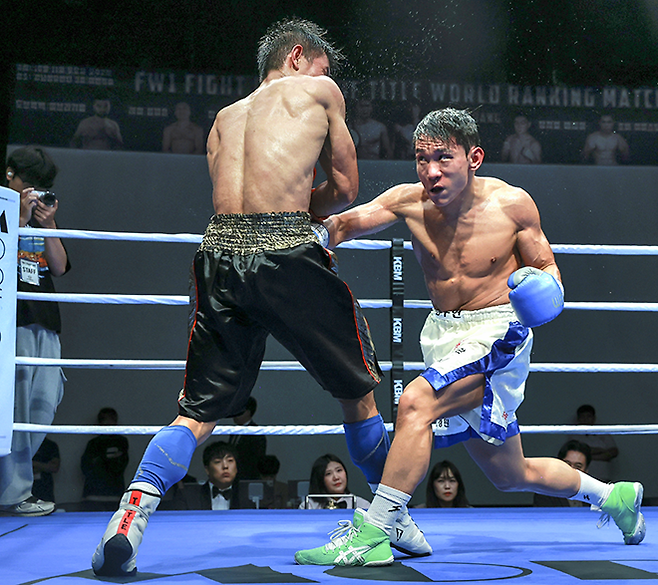 챔피언 조버 아미스토소가 2025년 10월 서울특별시 섬유센터 이벤트홀에서 사단법인 한국복싱커미션 KBM 밴텀급 타이틀 1차 방어전 도전자 김우현한테 맞고 있다. 김우현은 세계복싱협회 슈퍼플라이급 아시아 챔피언을 지냈다. 사진=FINAL FLASH 제공