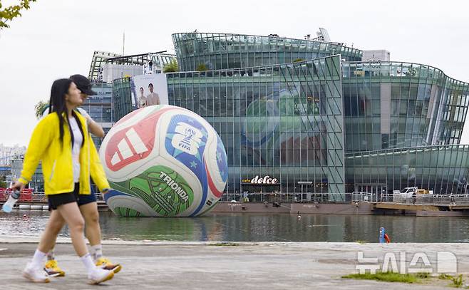 [서울=뉴시스] 김근수 기자 = 12일 서울 서초구 한강시민공원 세빛둥둥섬에 2026년 국제축구연맹(FIFA) 북중미 월드컵의 공인구 '트리온다'(TRIONDA)가 설치돼 있다. 아디다스는 트리온다의 국내 공개를 기념해 서울 세빛둥둥섬에서 'SOAP BALL' 이벤트를 개최한다고 밝혔다.2026년 국제축구연맹(FIFA) 북중미 월드컵의 공인구 '트리온다'(TRIONDA)는 세 개'(Tri)'의 '파도'(Onda)라는 뜻의 트리온다는 월드컵 공동 개최국인 캐나다·멕시코·미국을 기념하는 디자인으로 제작됐다. 빨강, 파랑, 초록의 국가 색상이 중앙 삼각형으로 이어져 세 나라가 하나되는 최초의 월드컵을 의미하며, 미국의 별, 캐나다의 단풍잎, 멕시코의 독수리 등 개최국의 대표 아이콘을 굵직한 그래픽과 엠보싱 기법으로 반영했다. 2025.10.12. ks@newsis.com