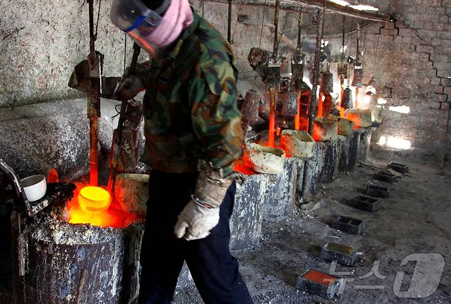 중국 내몽골 자치구 다마오 마을 인근의 희토류 제련 공장에서 한 작업자가 희토류 금속 란타늄을 주형에 부을 준비를 하고 있다. 2010.10.31 ⓒ 로이터=뉴스1 ⓒ News1 권영미 기자