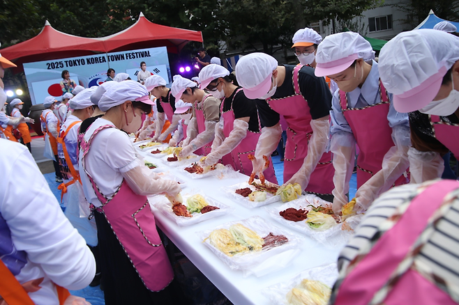 12~13일 일본 도쿄 신오쿠보 지역에서 열린 ‘코리아타운 페스티벌’에서 학생들이 김치 만들기 체험을 하고 있다. [신주쿠한국상인연합회]