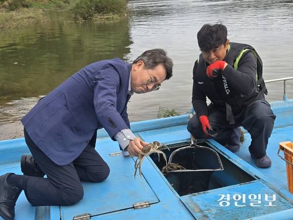 김동연 경기도지사가 14일 임진강 수위 점검 현장에서 ‘한탄강 청년어부’ 김은범씨를 만나 참게를 들어올리고 있다. 2025.10.14 /김태강기자 think@kyeongin.com