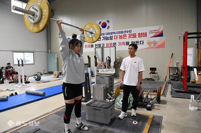 대전시 체육회 여자역도팀 한지안 선수가 서기택 감독이 지켜보는 가운데 체육관에서 바벨을 들어 올리고 있다.금상진 기자
