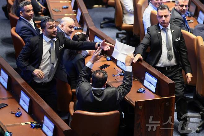 13일(현지시간) 이스라엘 의회(크네세트)에서 도널드 트럼프 미국 대통령이 연설하던 중 한 의원이 "팔레스타인을 (국가로) 인정하라＂고 적힌 종이를 들자 경비원들이 그를 제지하고 있다. 2025.10.13 ⓒ 로이터=뉴스1 ⓒ News1 김지완 기자