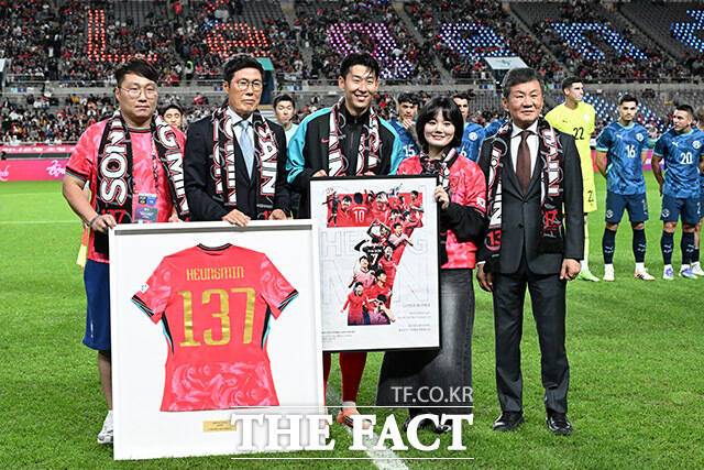 한국 남자 선수 A매치 최다 출전 달성에 성공한 손흥민(가운데)이 14일 오후 서울 마포구 서울월드컵경기장에서 열린 'Legend Old & New – From Cha, To. Son' 특별 행사에서 차범근 전 감독에게 기념 유니폼을 전달받은 뒤 기념촬영을 하고 있다./ 남용희 기자
