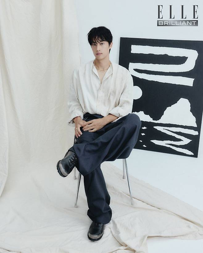 옐로 골드 소재의 로우 트위스트 코일이 특징인 ‘마라케시 컬렉션’ 네크리스는 1천5백만원대, 왼손에 착용한 ‘마라케시 컬렉션’ 링은 8백만원대 모두 MARCO BICEGO. 오른손에 착용한 옐로 골드 소재의 ‘플렉스잇’ 링은 4백만원대 FOPE. 드레이프 셔츠와 팬츠는 모두 가격 미정 JIYONGKIM. 슈즈는 48만8천원 CAMPER. ‘달무리’ 그림은 신우재의 작품.