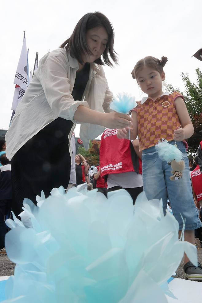 지난 6월21일 오후 서울 용산구 서울역 광장에서 아리셀 중대재해참사 1주기 추모대회에서 참가자들이 희생자들 추모하며 헌화하고 있다. 신소영 기자 viator@hani.co.kr