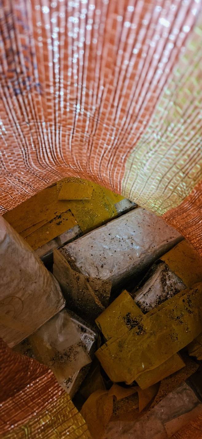 쓰레기 수거 자루 속에 담겨있는 벽돌 형태의 물체