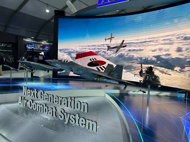 Models of Korea Aerospace Industries' KF-21 multirole fighter, right, and unmanned combat aircraft, left, are on display at the company's showroom at the 2023 Seoul ADEX. [MICHAEL LEE]