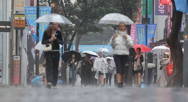 지난달 28일 비가 내리는 서울 중구 명동거리에서 시민 및 외국인관광객들이 우산을 쓴 채 걸어가고 있다.[연합]