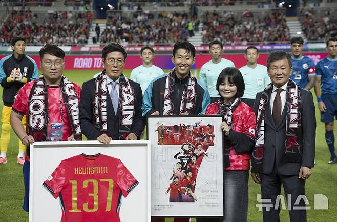 [서울=뉴시스] 김근수 기자 = 한국 남자 선수 A매치 최다 출전한 손흥민이 14일 오후 서울 마포구 서울월드컵경기장에서 열린 하나은행 초청 축구국가대표팀 친선경기 대한민국과 파라과이의 경기 시작 전 차범근 전 감독에게 기념 유니폼을 전달받고 기념촬영을 하고 있다.손흥민은 지난 10일 브라질전에 개인 통산 137번째 A매치에 출전했다.  차범근 전 대표팀 감독, 홍명보 대표팀 감독(이상 136경기)을 제치고 한국 남자 축구 역사상 최다 출전 기록 보유자가 됐다. 2010년 12월 시리아전 데뷔 이후 15년 만이다.  2025.10.14. ks@newsis.com