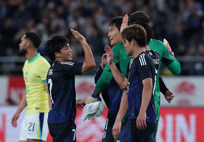 일본 선수들이 14일 일본 도쿄에서 열린 브라질과 평가전에서 3-2로 승리한 뒤 승리의 하이파이브를 하고 있다. 도쿄 | 로이터연합뉴스