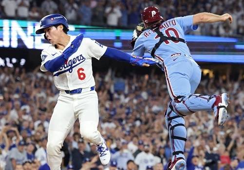 김혜성(왼쪽)이 10일(한국시간) 필라델피아 필리스와 2025 메이저리그 포스트시즌 NLDS 4차전 연장 11회말 2사 만루서 태그를 피해 결승득점을 기록하고 있다. /AFPBBNews=뉴스1