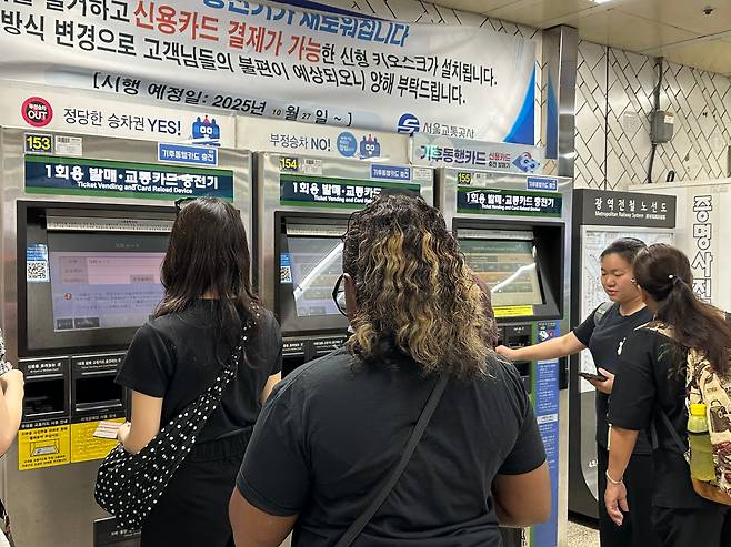 지난 24일 오전 서울 지하철 4호선 명동역에서 교통카드 충전기 앞에 서 있는 외국인 관광객들의 모습. /김영우 기자