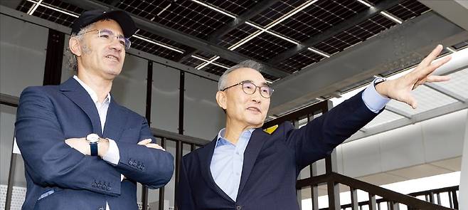 < 서울 도심 보는 카프·김영섭 > 알렉스 카프 팰런티어 최고경영자(CEO·왼쪽)와 김영섭 KT 대표는 14일 서울 세종로 KT광화문빌딩 웨스트 옥상에 함께 올라 시내 전경을 감상했다. 김 대표가 광화문광장에 대해 설명하고 있다.  KT 제공