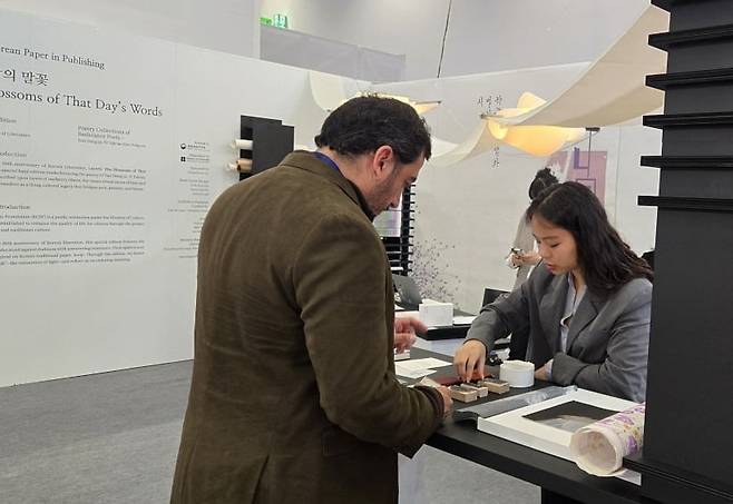 해외 출판 관계자가 한국공예·디자인문화진흥원의 부스에서 한지에 도장 찍기 체험을 하고 있다. 프랑크푸르트=구은서 기자