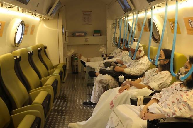 서울 영등포구에 위치한 한림대한강성심병원 고압산소치료센터의 다인용 장비(챔버) 내부에서 화상 환자들이 고압산소치료 장비 내에서 산소호흡기를 착용한 채 고압산소치료를 받고 있다. 이 장비 3대에서 환자 최대 36명을 동시에 치료할 수 있다/사진=한림대한강성심병원