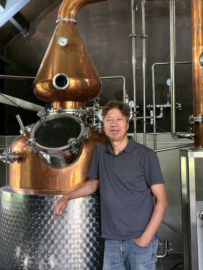 증류기 앞에서 포즈를 취한 박성호 대표. 최현태 기자
