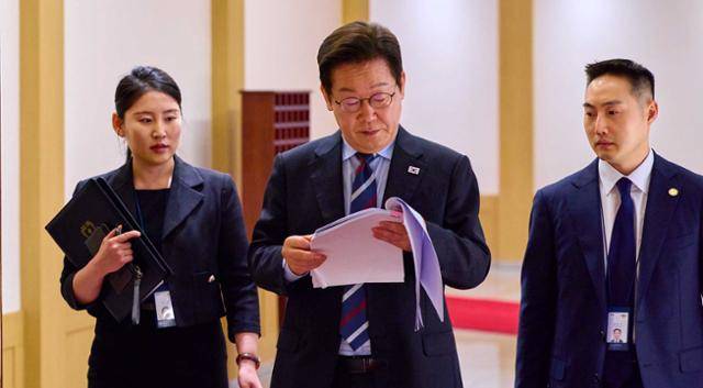 이재명 대통령이 지난달 15일 서울 용산 대통령실에서 서류를 검토하며 이동하고 있다. 대통령실 제공