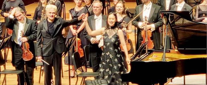 지난 14일 서울 예술의전당에서 열린 런던 필하모닉 공연에서 지휘자 에드워드 가드너(왼쪽 두 번째)와 피아니스트 손열음이 손을 잡은 채 관객에게 인사하고 있다.  /이주현 기자
