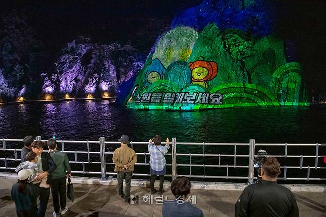 주민과 관광객들이 미디어파사드 시험 운영을 지켜보고 있다.[울릉군 제공]