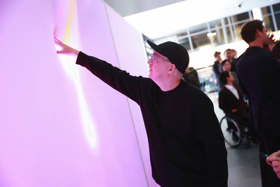 인터렉티브 전시로 표현한 히트텍 캐시미어를 체험중인 현대예술가 카우스. 사진 유니클로